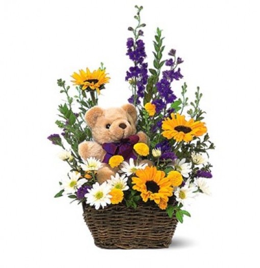 Canasta con flores primaverales y oso de peluche